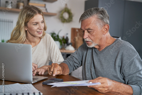 Senior man with adult daughter looking for solution in financial problem