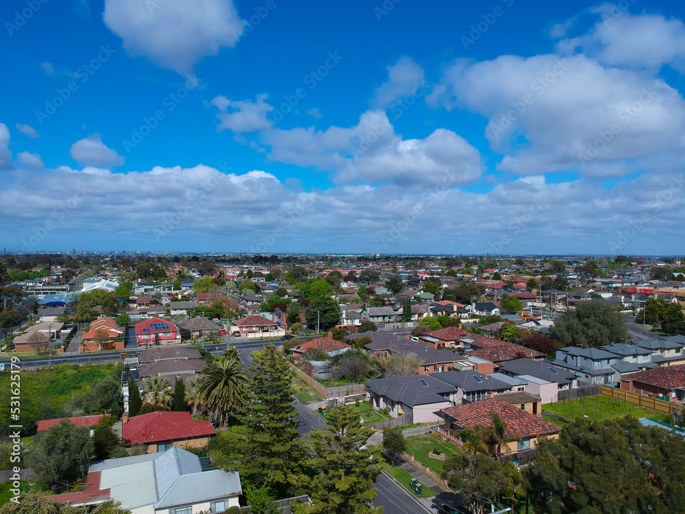 Fototapeta premium Panoramic aerial Drone view of Melbournes suburbs and CBD looking down at Houses roads and Parks Victoria Australia. Beautiful colours at Sunset