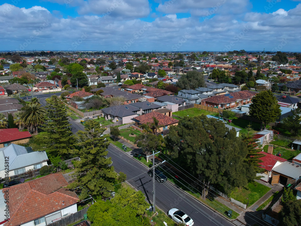 Panoramic aerial Drone view of Melbournes suburbs and CBD looking down at Houses roads and Parks Victoria Australia. Beautiful colours at Sunset