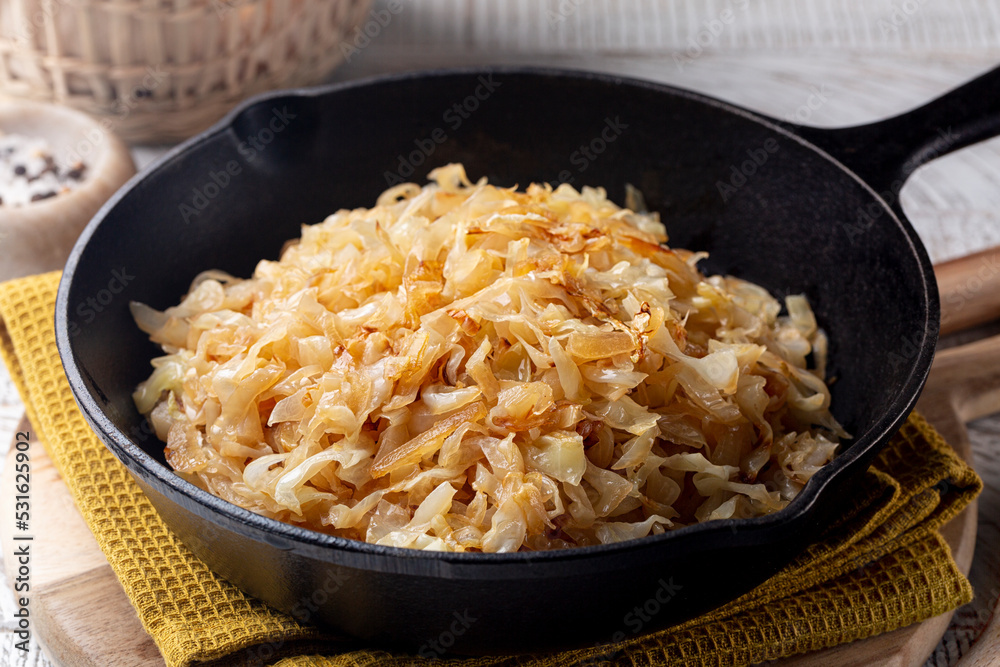 Quick Pan fried Sauerkraut or Crauti. Finely cut white cabbage cooked with fried onion and white wine. Close-up. Quick Pan fried Sauerkraut or Crauti. Finely cut white cabbage cooked with fried onion and white wine. Close-up.