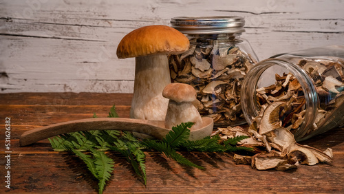 Food photography background - Fresh and dried forest mushrooms / Boletus edulis (king bolete) / penny bun / cep / porcini / mushroom, glasses for storage on table photo