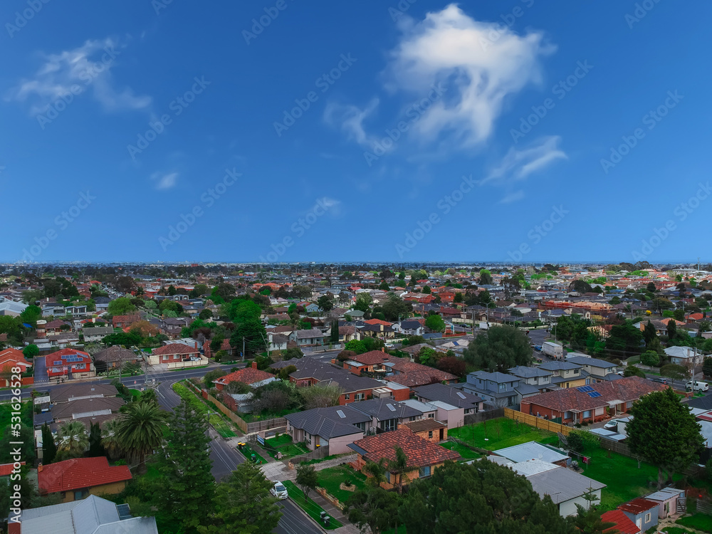 Obraz premium Panoramic aerial Drone view of Melbournes suburbs and CBD looking down at Houses roads and Parks Victoria Australia. Beautiful colours at Sunset