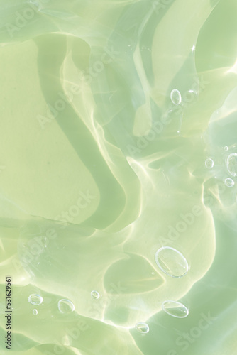 The texture of a green gel or serum with hyaluronic acid for the face. Cosmetic transparent liquid cream with oxygen bubbles. Wellness and beauty concept. Sanitizer, virus protection.