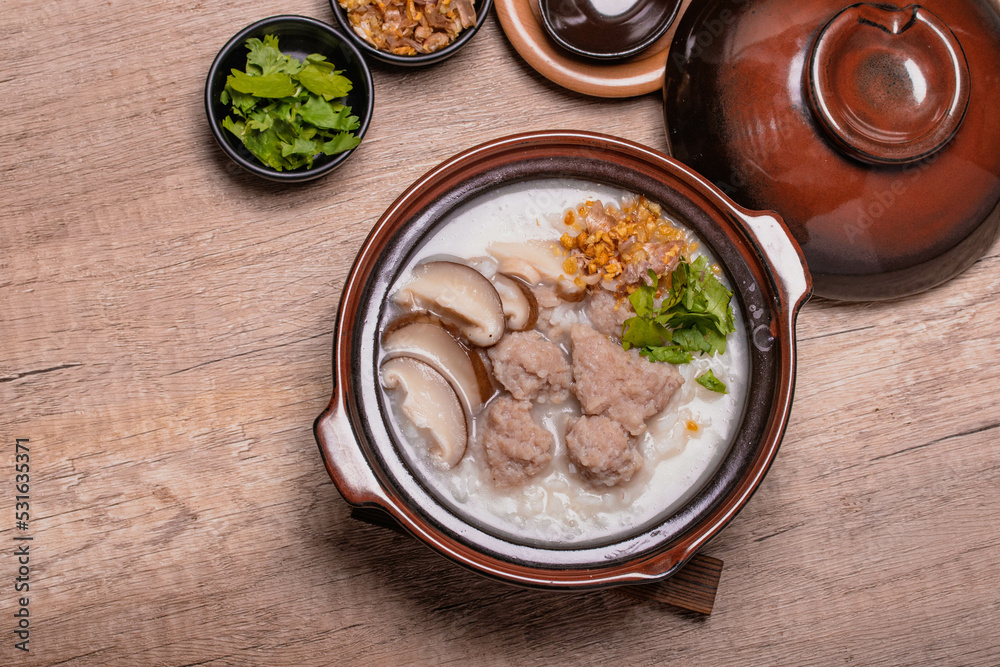 Pork porridge with shiitake mushrooms in brown cups topped with coriander and fried garlic Pork porridge with shiitake mushrooms in brown cups topped with coriander and fried garlic