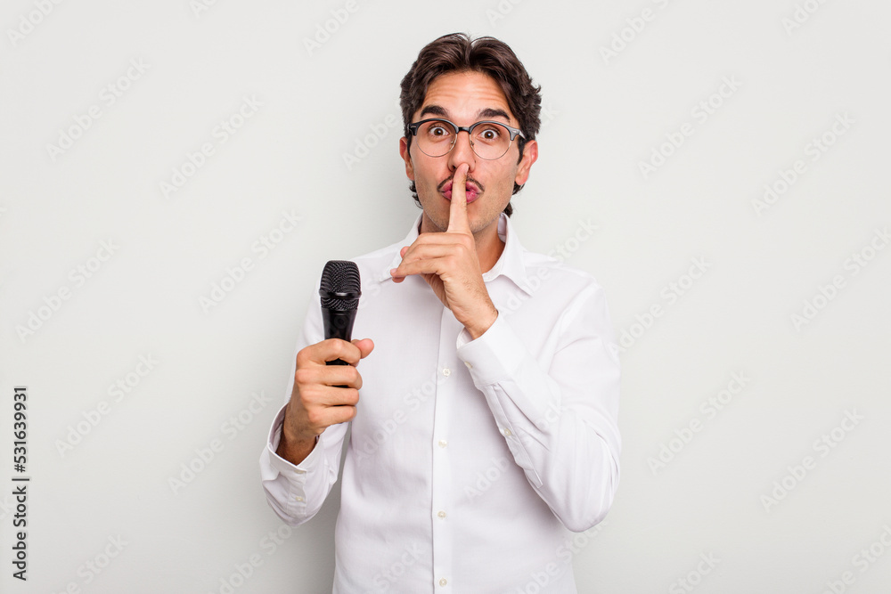 Young hispanic singer man isolated on white background keeping a secret or asking for silence.