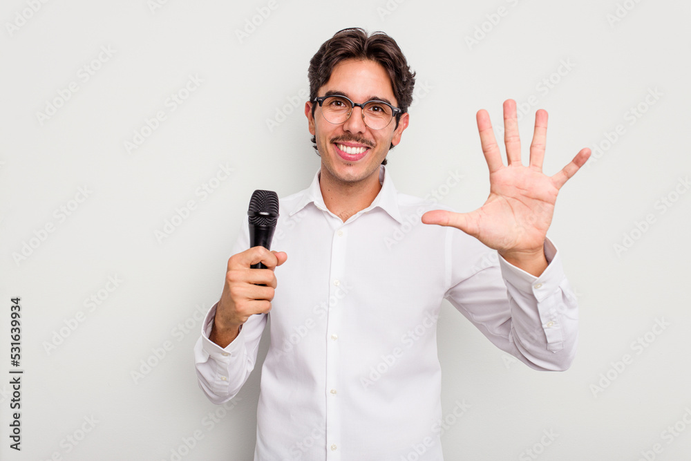 Young hispanic singer man isolated on white background smiling cheerful showing number five with fingers. Young hispanic singer man isolated on white background smiling cheerful showing number five with fingers.