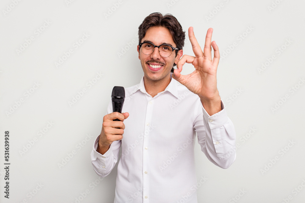 Young hispanic singer man isolated on white background cheerful and confident showing ok gesture. Young hispanic singer man isolated on white background cheerful and confident showing ok gesture.