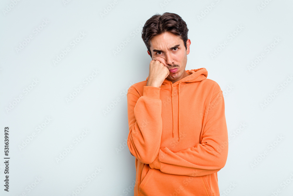 Young hispanic man isolated on blue background who feels sad and pensive, looking at copy space. Young hispanic man isolated on blue background who feels sad and pensive, looking at copy space.