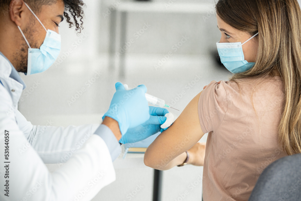 Close up of a doctors hands giving vaccine Close up of a doctors hands giving vaccine