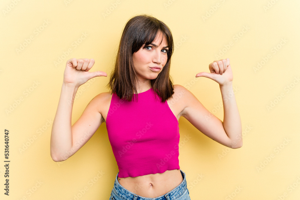 Young caucasian woman isolated on yellow background feels proud and self confident, example to follow. Young caucasian woman isolated on yellow background feels proud and self confident, example to follow.