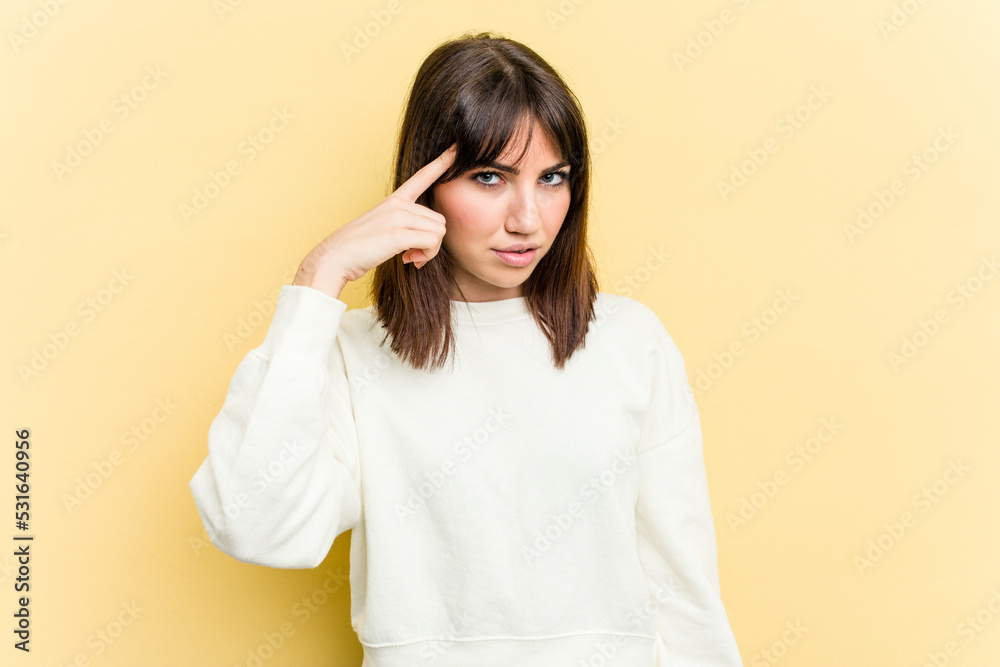 Young caucasian woman isolated on yellow background pointing temple with finger, thinking, focused on a task. Young caucasian woman isolated on yellow background pointing temple with finger, thinking, focused on a task.