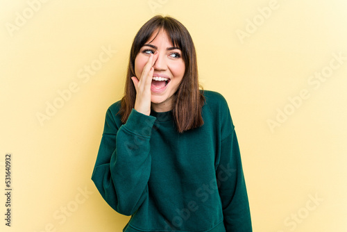 Young caucasian woman isolated on yellow background shouting excited to front. © Asier