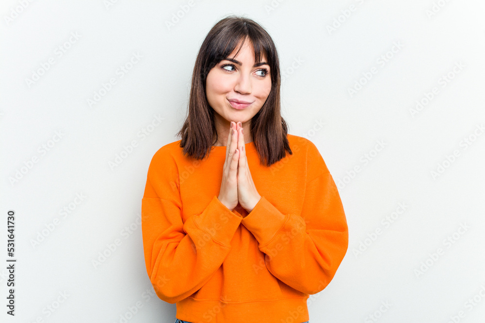 Young caucasian woman isolated on white background praying, showing devotion, religious person looking for divine inspiration. Young caucasian woman isolated on white background praying, showing devotion, religious person looking for divine inspiration.