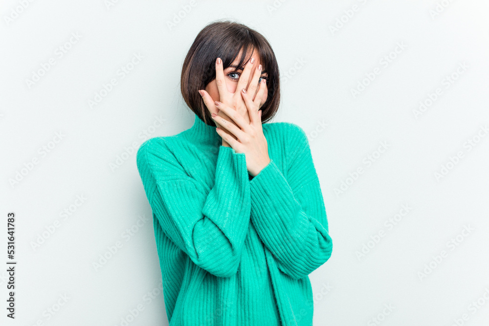 Young caucasian woman isolated on white background blink through fingers frightened and nervous. Young caucasian woman isolated on white background blink through fingers frightened and nervous.