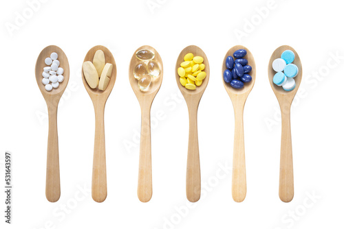 Variety of vitamin capsules and mineral pills in wooden spoon isolated on white background. Top view. Dietary supplement health care product.