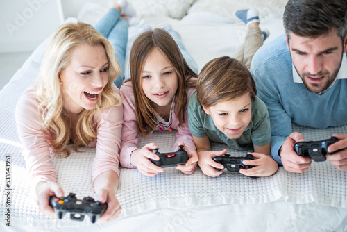 Family spending time together in bedroom, playing games, and playing with their dog