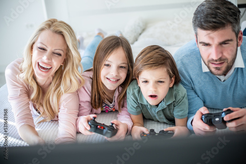 Family spending time together in bedroom  playing games  and playing with their dog