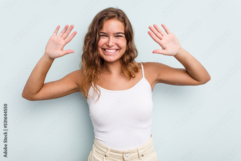 Young caucasian woman isolated on blue background showing number ten with hands. Young caucasian woman isolated on blue background showing number ten with hands.