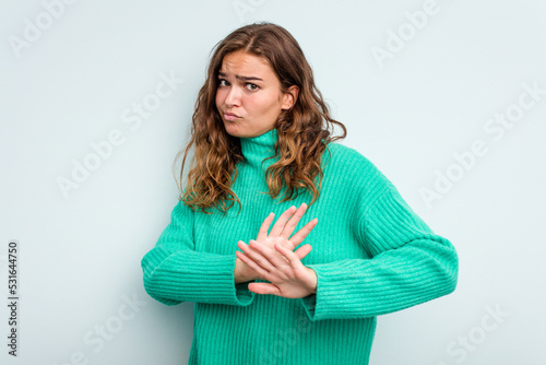 Young caucasian woman isolated on blue background doing a denial gesture