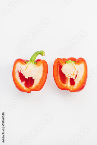 Fresh ripe sweet red bell pepper cut in half on white background