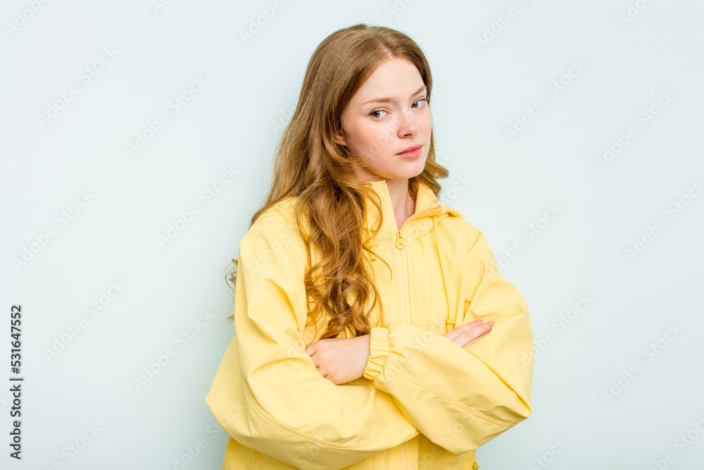 Young caucasian woman isolated on blue background suspicious, uncertain, examining you. Young caucasian woman isolated on blue background suspicious, uncertain, examining you.