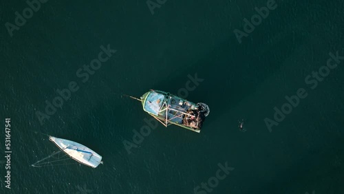 Aerial top dow view of many boats moored in tranquil sea water. Day time photo