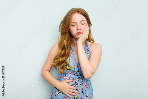 Young caucasian woman isolated on blue background blows cheeks, has tired expression. Facial expression concept. © Asier