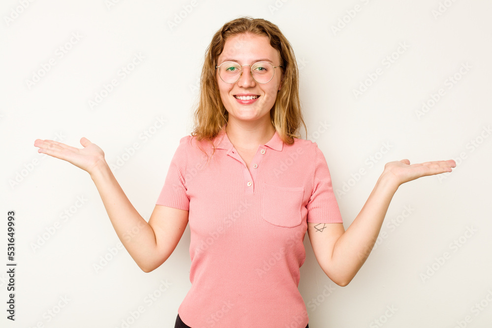 Young caucasian woman isolated on white background makes scale with arms, feels happy and confident. Young caucasian woman isolated on white background makes scale with arms, feels happy and confident.
