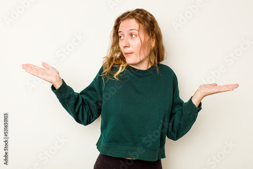 Young caucasian woman isolated on white background confused and doubtful shrugging shoulders to hold a copy space.