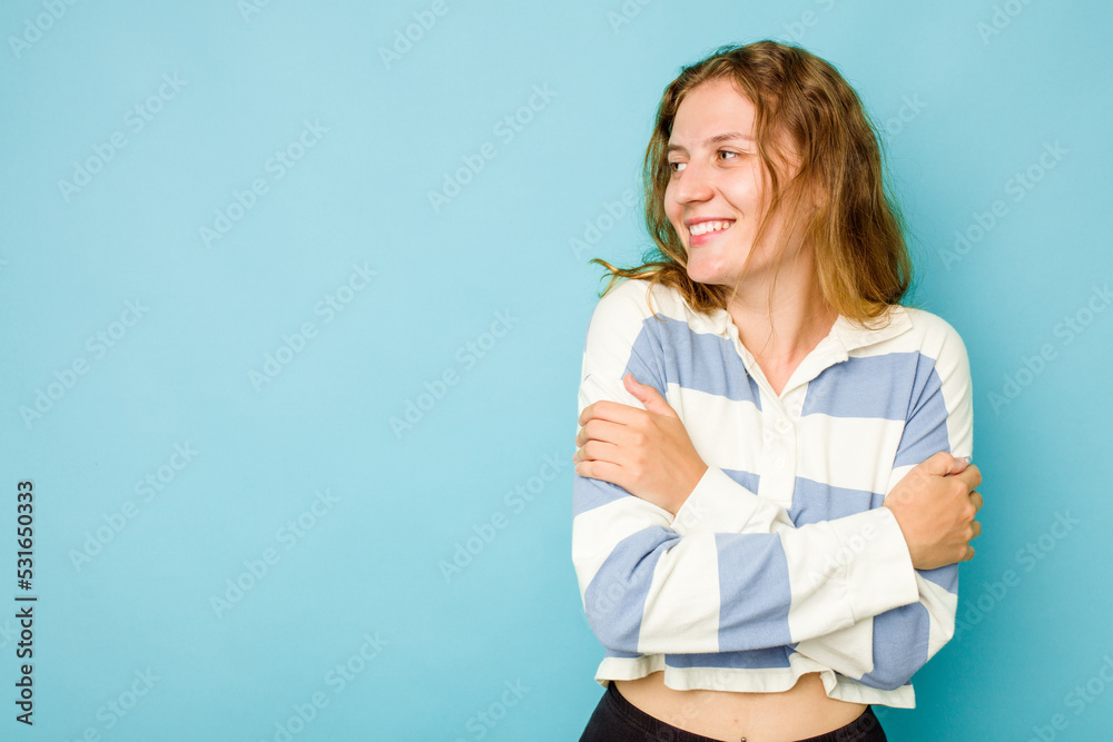 Young caucasian woman isolated on blue background smiling confident with crossed arms. Young caucasian woman isolated on blue background smiling confident with crossed arms.