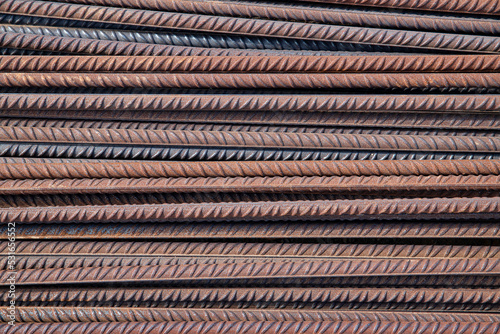 Background of reinforcing long bars, also known in the construction industry as rebars, durable iron rods with indentations used in concrete making to strengthen and improve its quality under tension