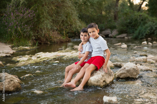 two united children bathe in the river looking at the camera