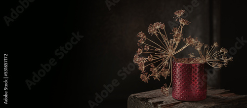 Art autumn dried flowers still life in a rustic style on a dark wooden background. Autumnal composition for Thanksgiving Day