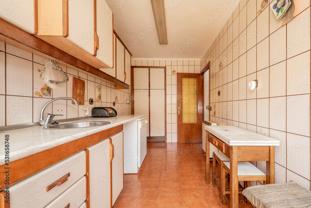 Fototapeta premium Antique kitchen with edge wood cabinets, folding table with stools, and light brown flooring