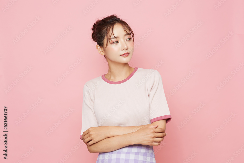 Obraz premium スポーティなファッションをした若い女性のピンク背景のポートレート