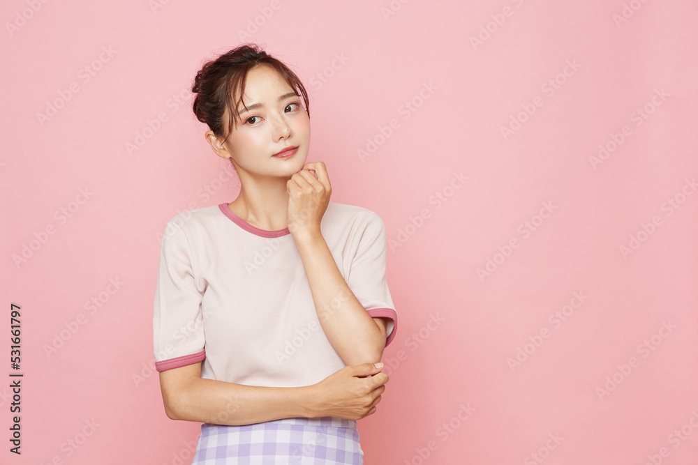 スポーティなファッションをした若い女性のピンク背景のポートレート スポーティなファッションをした若い女性のピンク背景のポートレート
