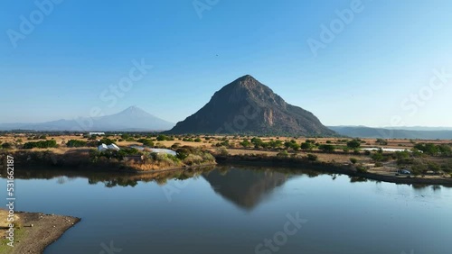 Beautiful Water Reflection of El Chumil Mountain with Popcatepetl Volcano in Background, Rising Aerial with Copy Space in Sky photo