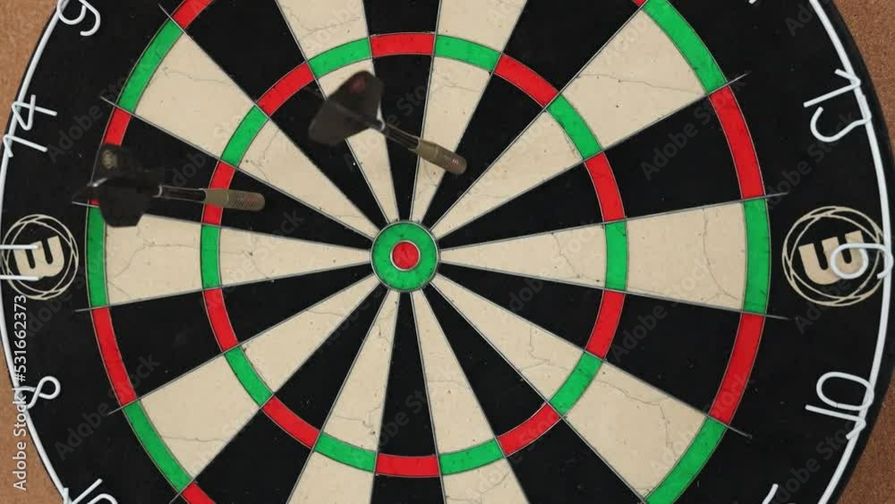 Person playing darts and removing them with hand. Person playing darts and removing them with hand.