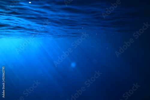 ocean underwater rays of light background, under blue water sunlight