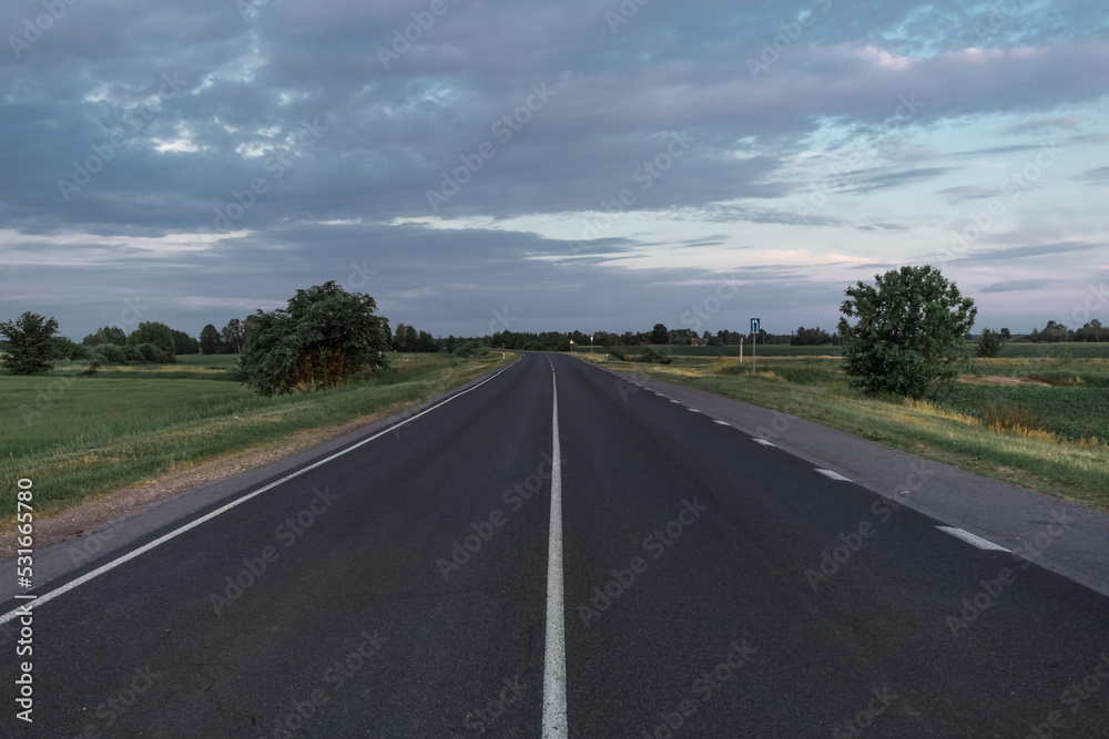 Asphalt road going into the distance on a summer evening