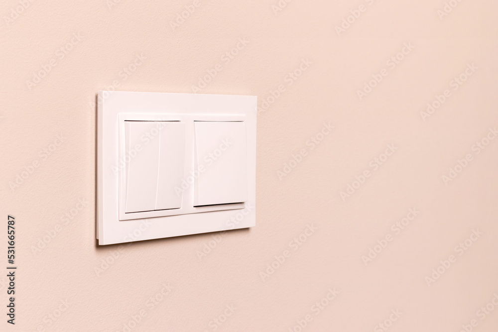Group of white electrical switches on modern beige wall Group of white electrical switches on modern beige wall
