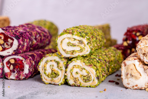 Assortment of Turkish delight with pistachio on a gray background. Mixed Turkish Delight. Close-up. local name fistikli fitil lokum photo