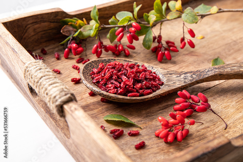 Foto Pile of dried Berberis vulgaris also known as common barberry, European barberry or barberry on plate in home kicthen