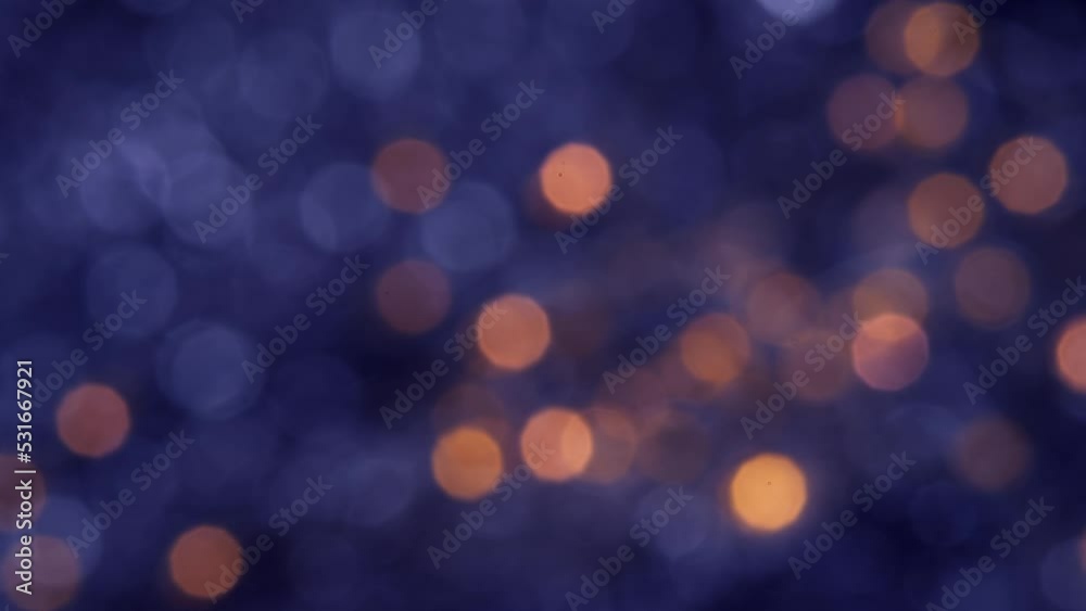Abstract blurred glowing golden lights in slow motion. Blue bokeh Christmas and New Year background. Abstract blurred glowing golden lights in slow motion. Blue bokeh Christmas and New Year background.