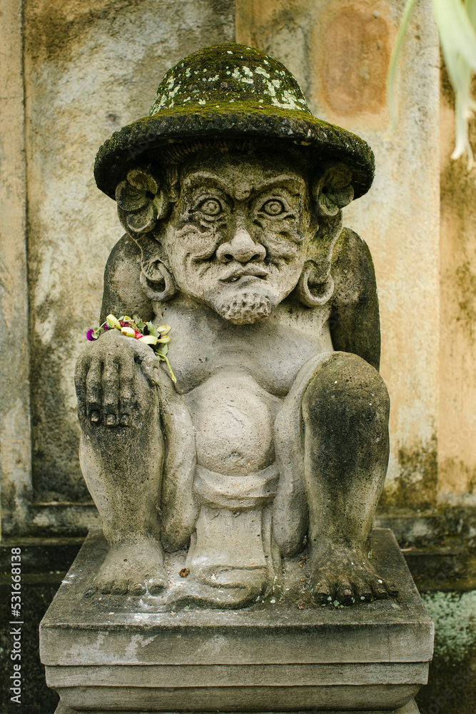 Traditional guard statue in the street carved from stone in Bali, Indonesia.