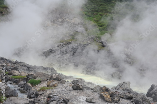 Acidic hot spring stream water with hydrochloric acid emitting steam in mountain valley at Tamagawa Onsen Hot spring in Semboku city, Akita prefecture, Tohoku region, northern Japan, Asia