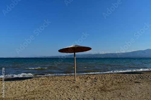 lonely umbrella on the coast of the sea on a clear morning © NADEZHDA RYBAK