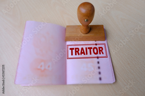 International biometric Russian passports of citizen of Russian Federation with red cover close up on light background, stamp of traitor. Stop illegal migration concept accusation of treason photo