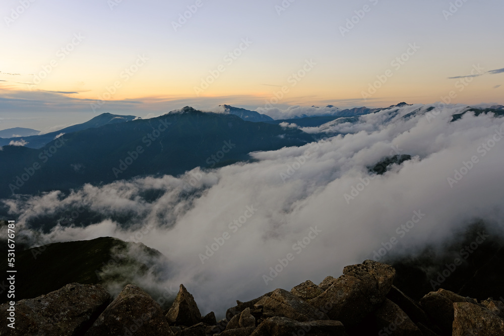 北アルプスの笠ヶ岳の山頂より滝雲を夕方に見る