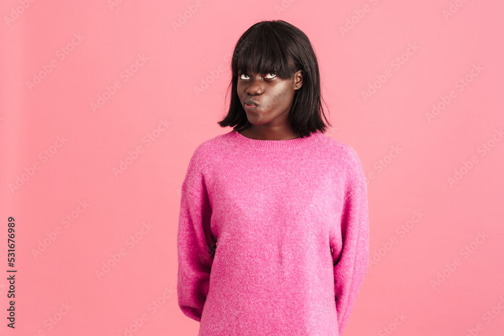 Young beautiful pensive african woman in pink sweater Young beautiful pensive african woman in pink sweater